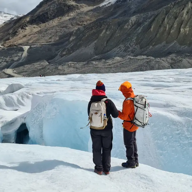 Zwei Personen mit Rucksäcken stehen auf Gletscher in Kanada