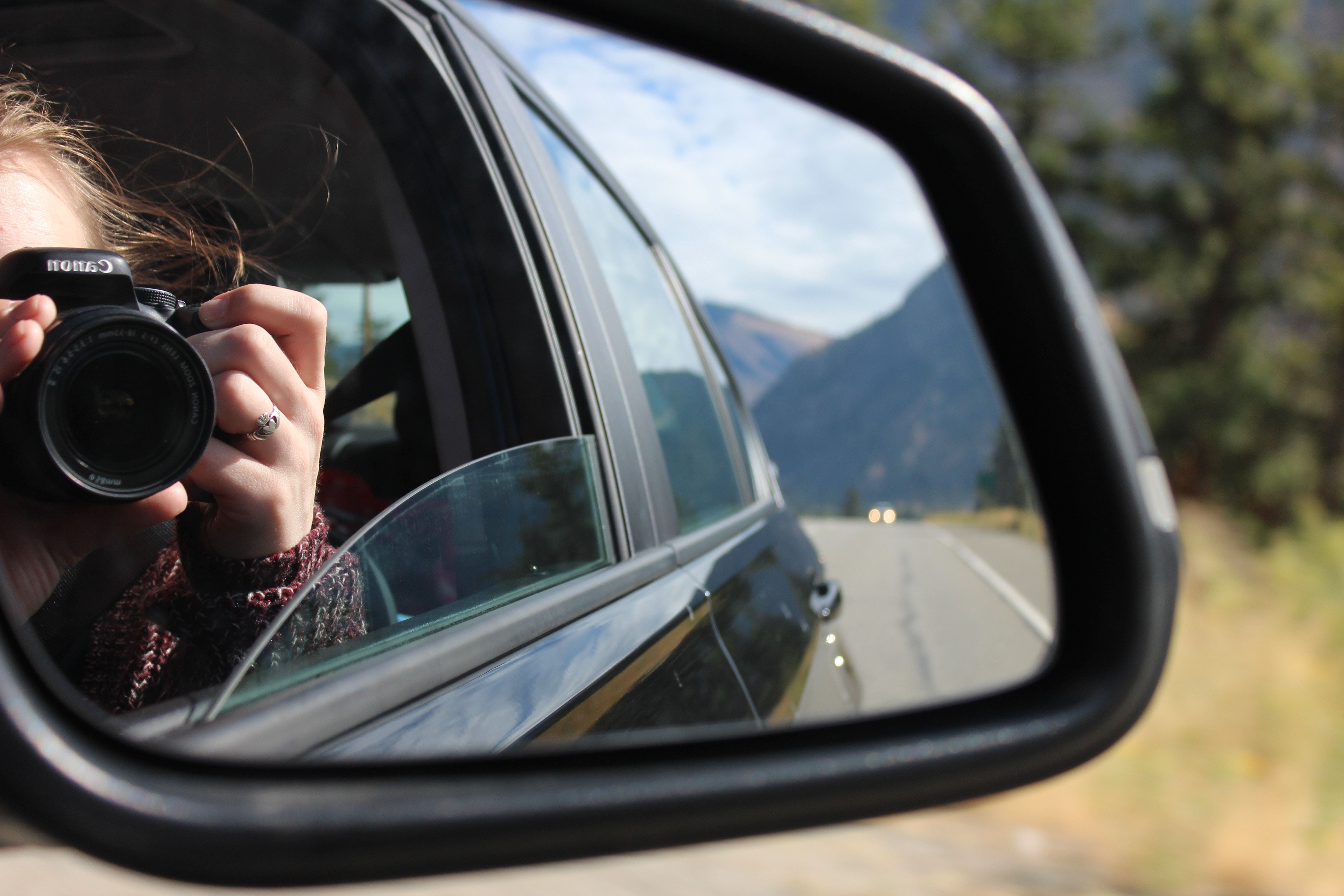 A lady takes a photo from a car window in the Okanagan Valley, Canada