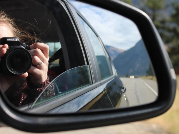 A lady takes a photo from a car window in the Okanagan Valley, Canada