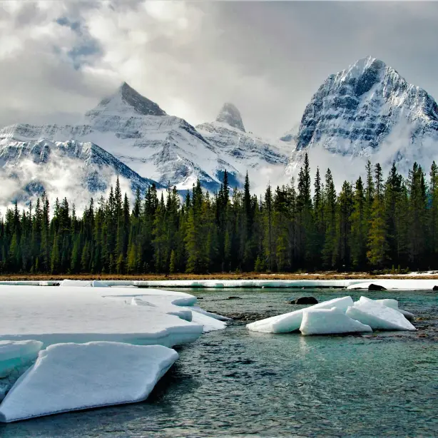 Besneeuwde bergtoppen en een bevroren rivier langs de Icefields Parkway in Canada