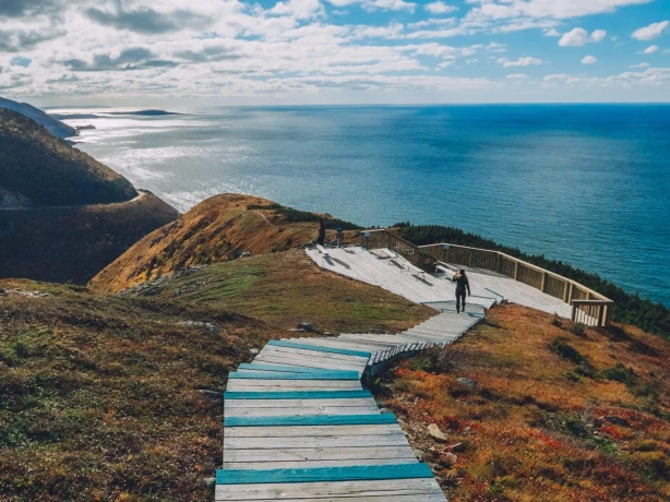 Luftaufnahme einer Treppe, die von einem Berg hinunter zum Meer führt.
