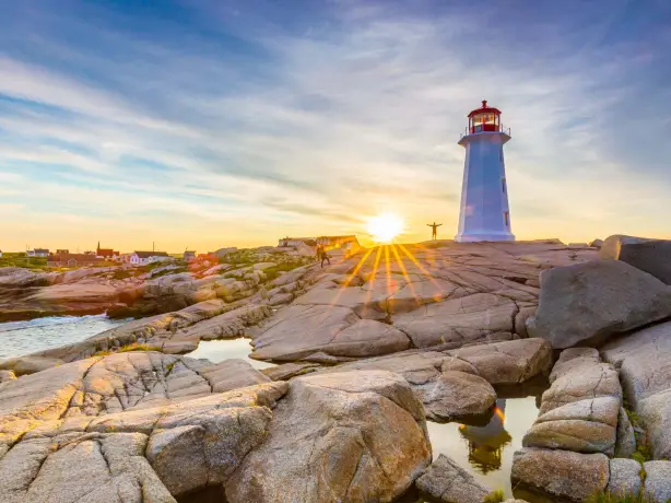 In Peggy’s Cove an der Atlantikküste Kanadas thront ein Leuchtturm auf den Felsen, während die Sonne hinter ihm untergeht