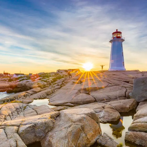 In Peggy’s Cove an der Atlantikküste Kanadas thront ein Leuchtturm auf den Felsen, während die Sonne hinter ihm untergeht