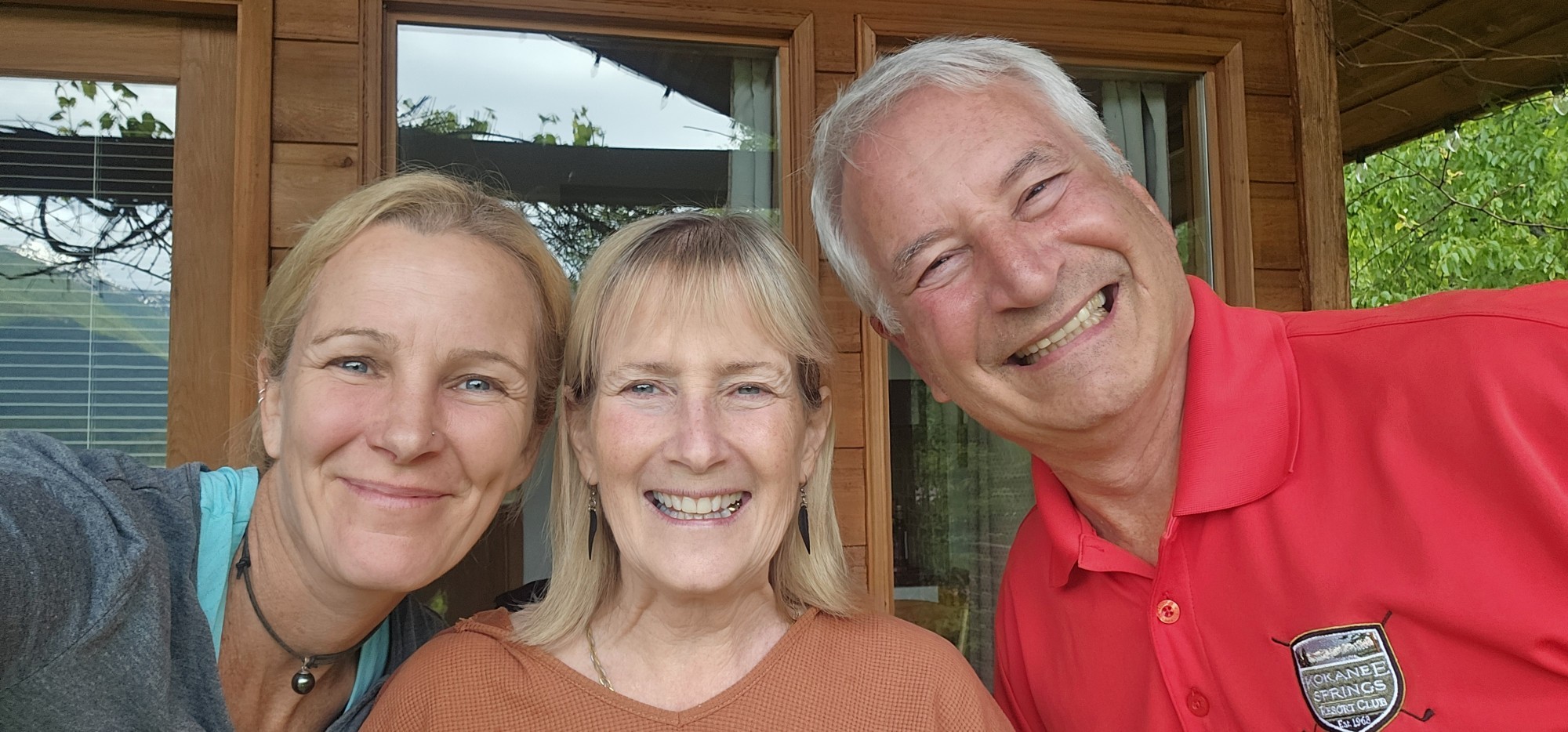 Zwei lächelnde Frauen und ein lächelnder Mann