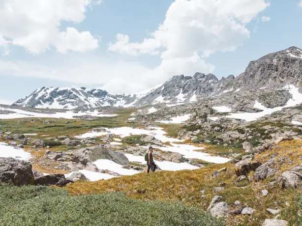 Person wandert durch Felslandschaft in Kanada mit restlichem Schnee