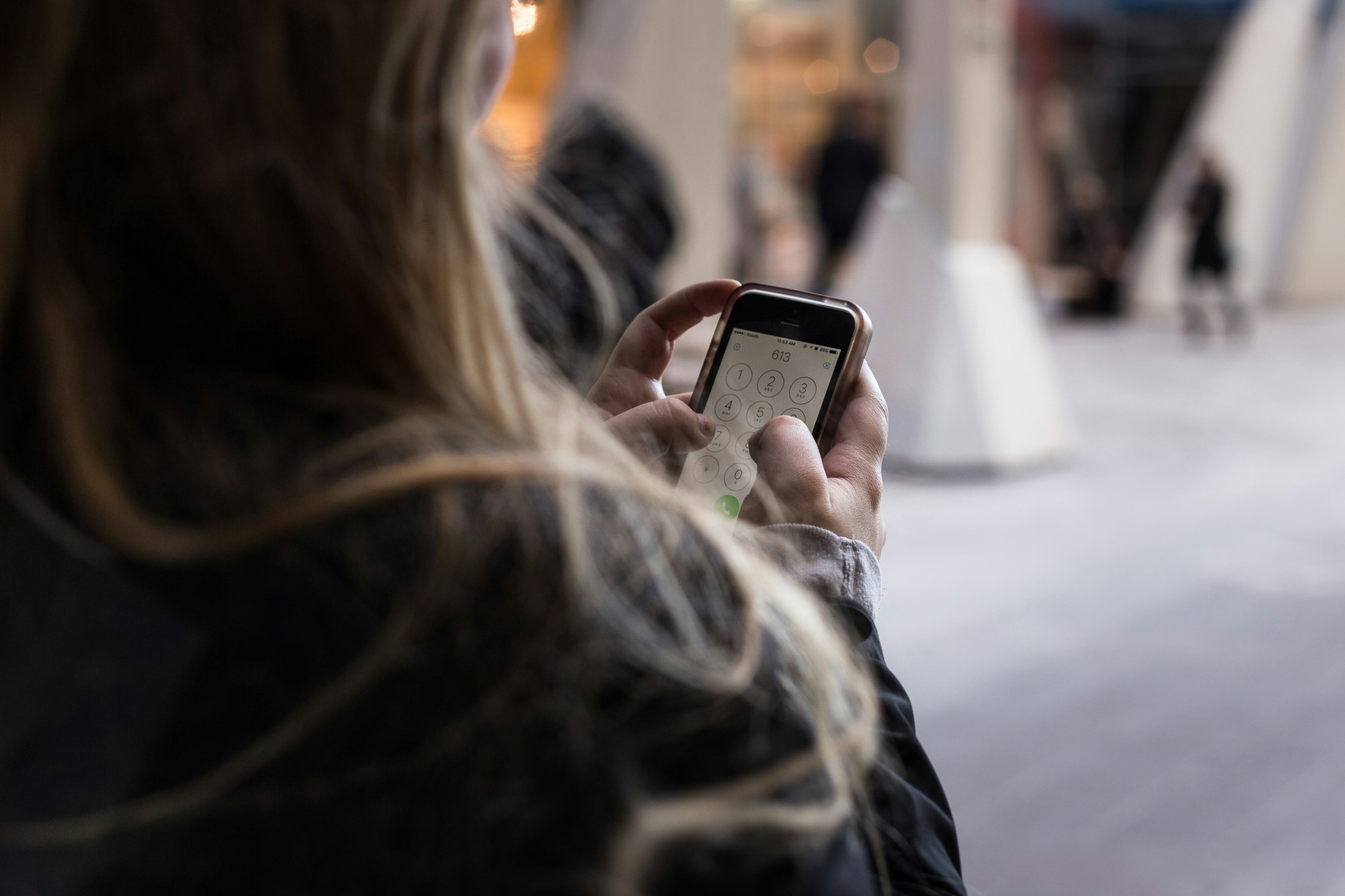 Frau tippt Zahlen auf Handy ein