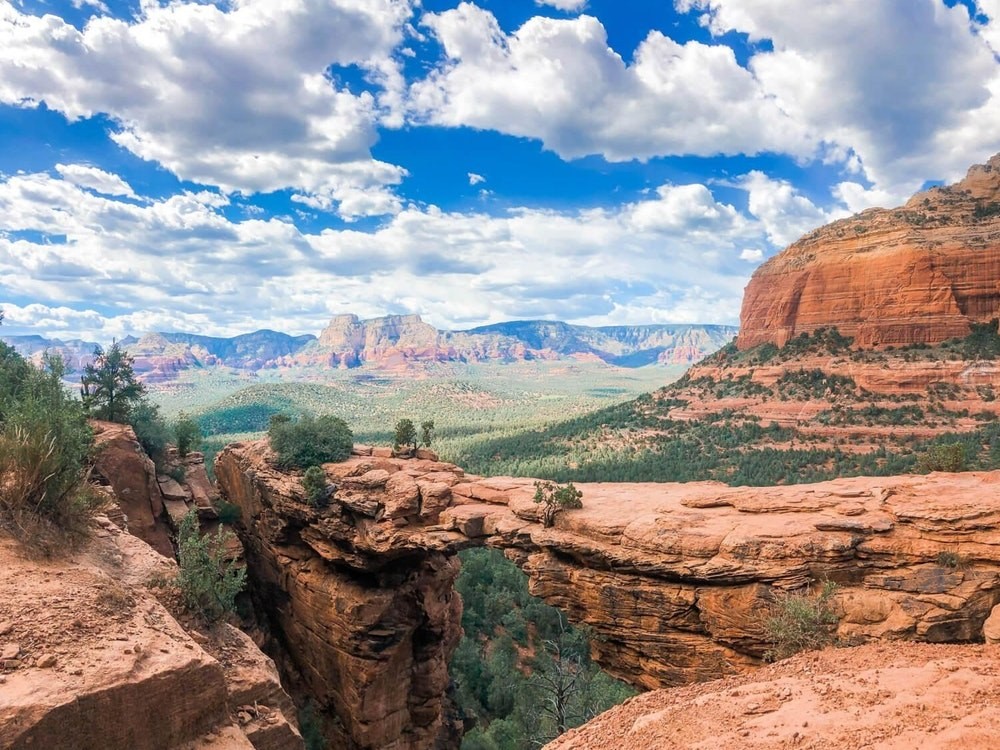Natürliche Felsbrücke mit rotem Canyon im Hintergrund in Sedona, USA