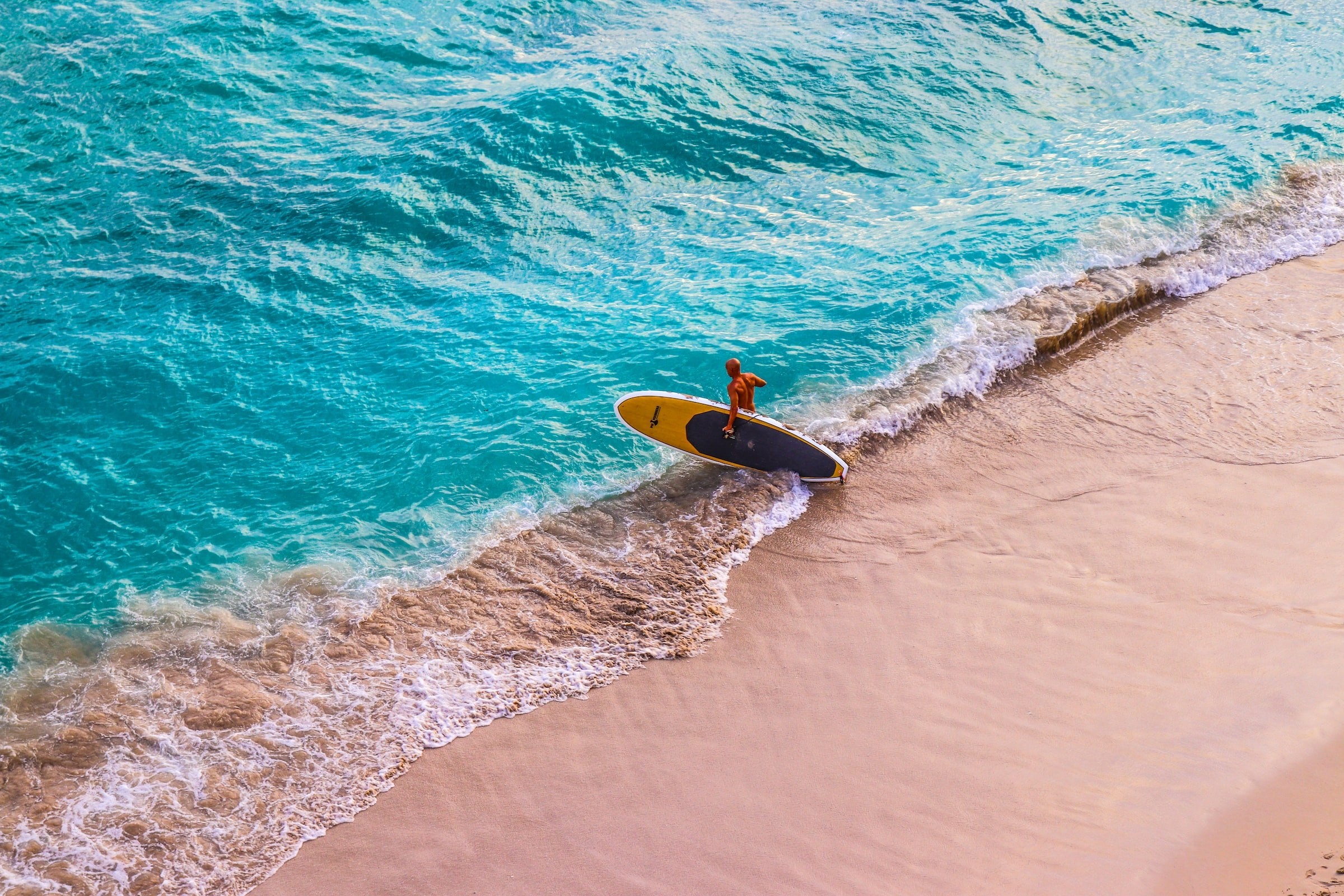 Een paddleboarder gaat het water in bij Waikiki Beach op Hawaï