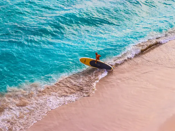 Ein Paddleboarder geht am Wakiki Beach auf Hawaii ins Meer