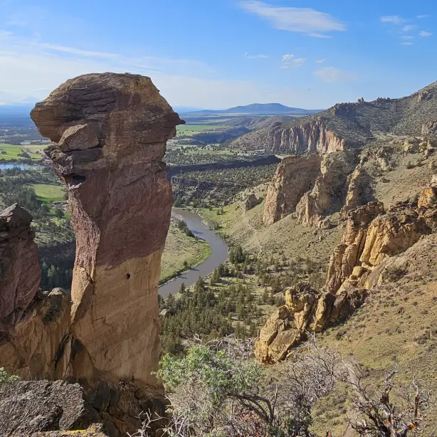 De Monkey Face-rotsformatie in Smith Rock State Park met uitzicht op het dal op de achtergrond