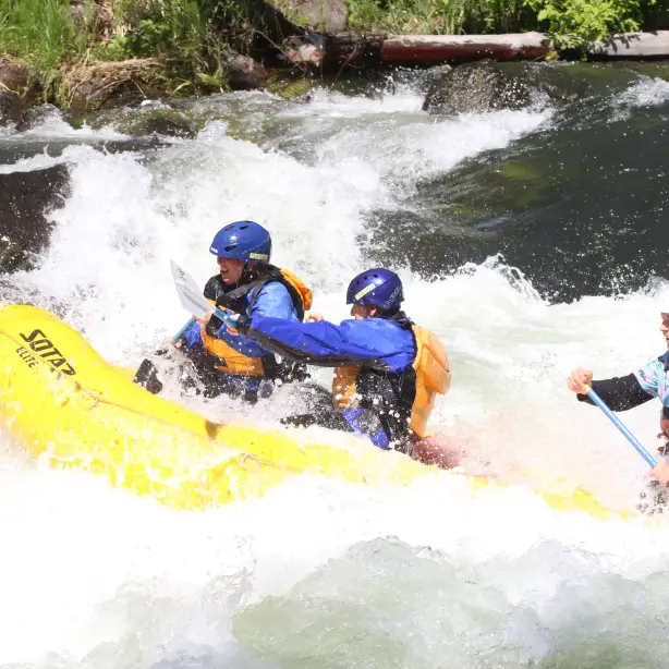 Drie mensen in een gele boot raften over de Columbia River