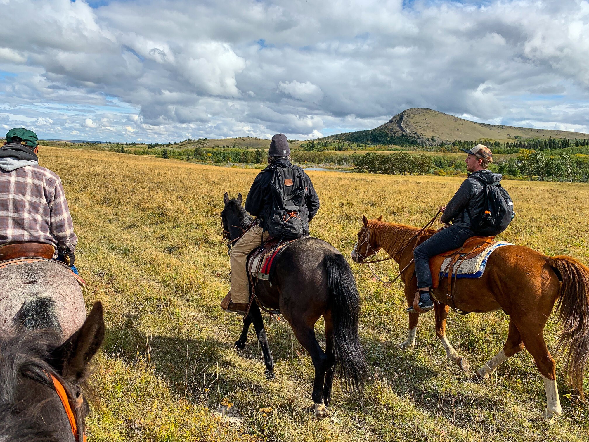Mitglieder der Blackfeet Nation nehmen einen Touristen mit auf ein Reitabenteuer durch die Landschaften von Montana, USA.