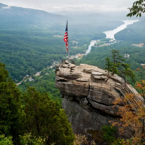Amerikaanse vlag bij een uitzichtpunt in Chimney Rock State Park met groene bergen op de achtergrond
