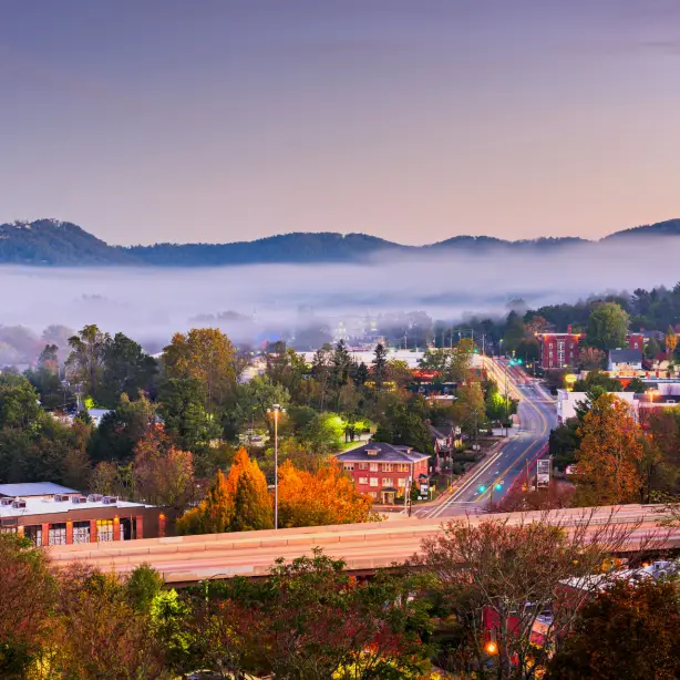 Laaghangende wolken als een deken boven het sfeervol verlichte Asheville in de avond