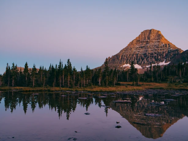 See mit Berg im Hintergrund bei Sonnenuntergang