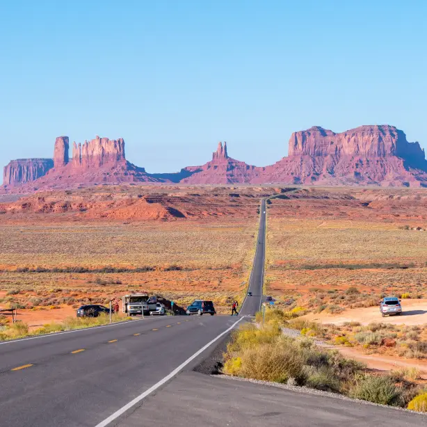Straße durch die Wüste mit Monument Valley im Hintergrund