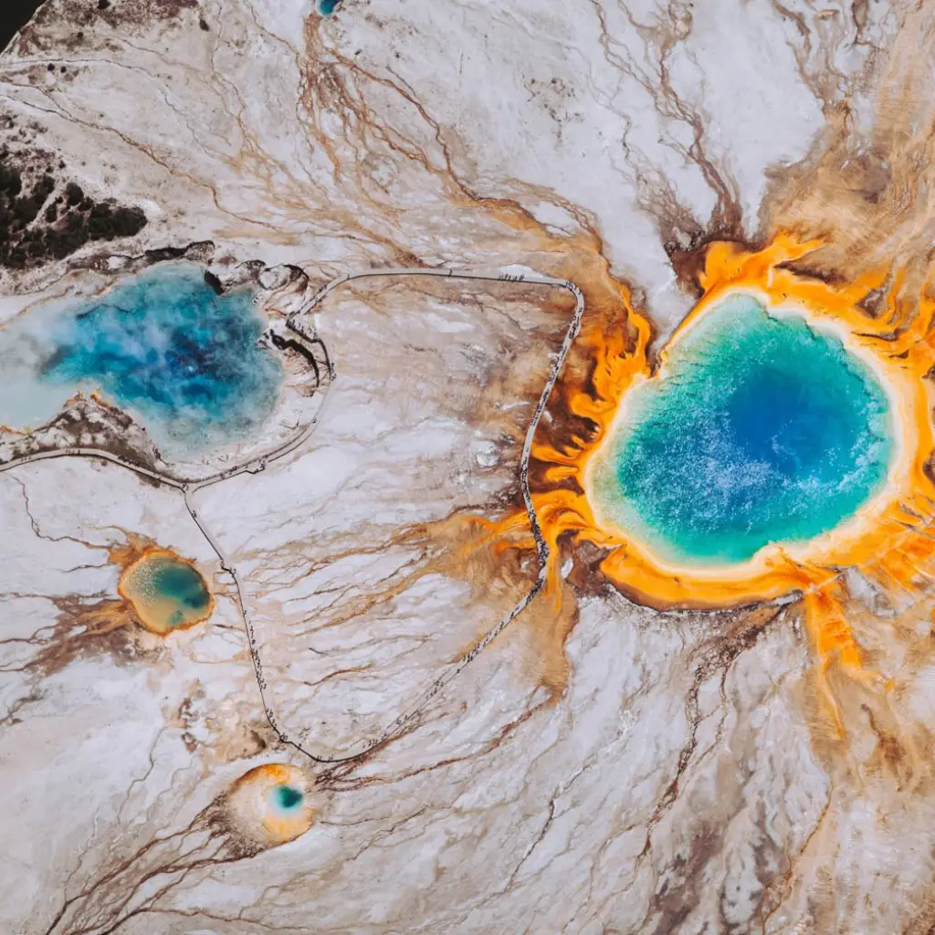 Türkisblaue heiße Quelle mit orangefarbenen Mineralablagerungen im Yellowstone Nationalpark