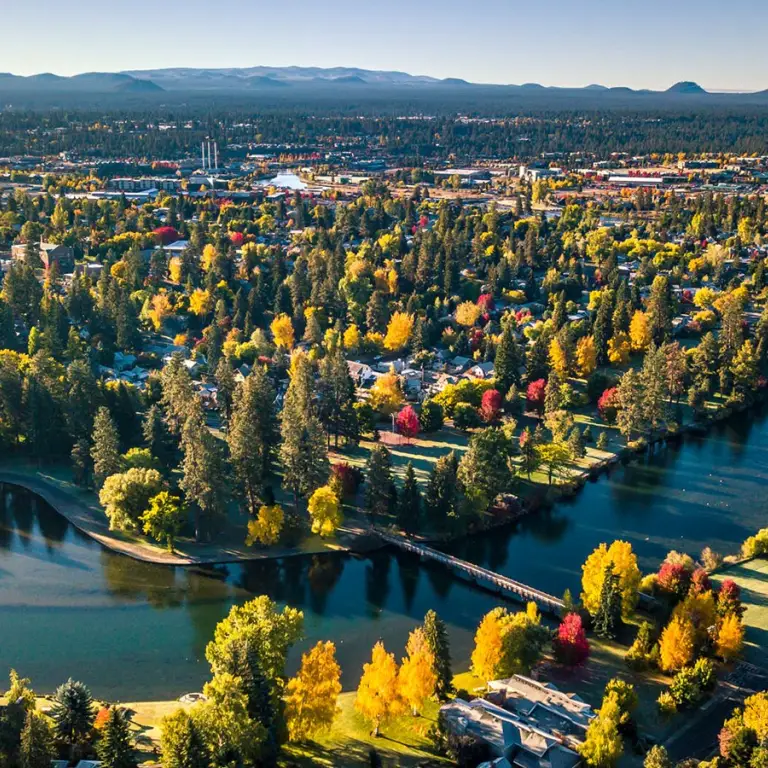 Een luchtfoto van het groene Drake Park met de Deschutes River op de voorgrond in Bend
