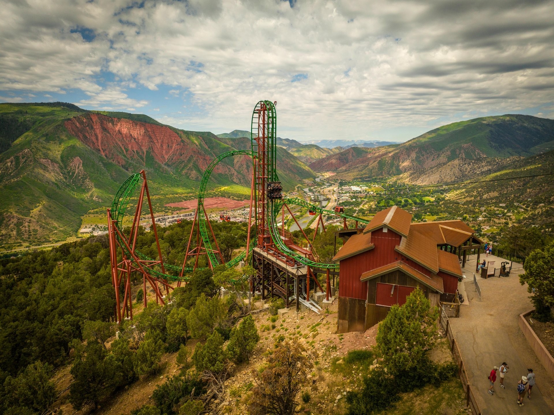 Achterbahn im Glenwood Caverns Adventure Park hoch über Glenwood Springs in Colorado. Im Hintergrund erstrecken sich die bewaldeten Berge und das Tal des Colorado River.