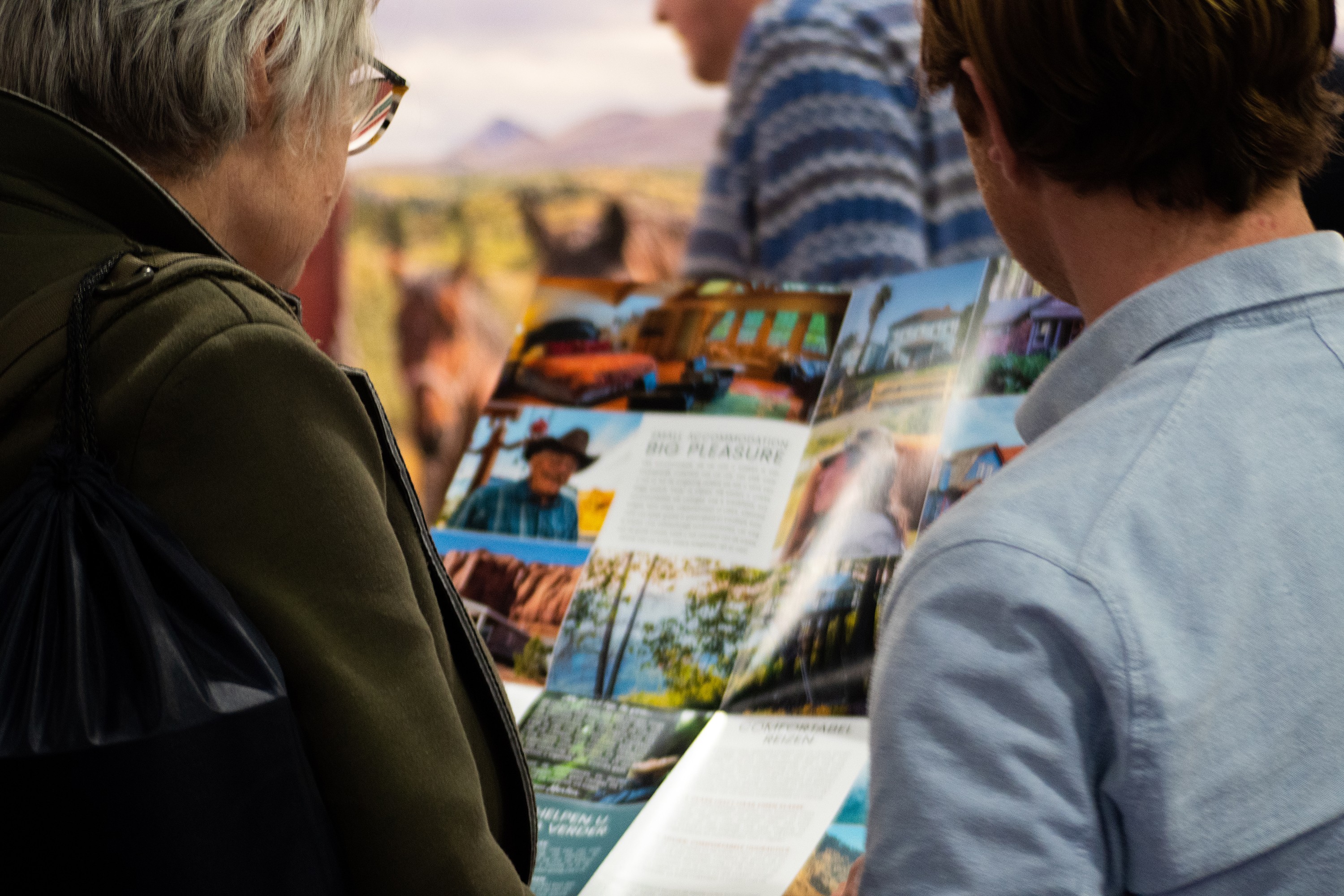 Two people read a Little America brochure to plan their trip to North America