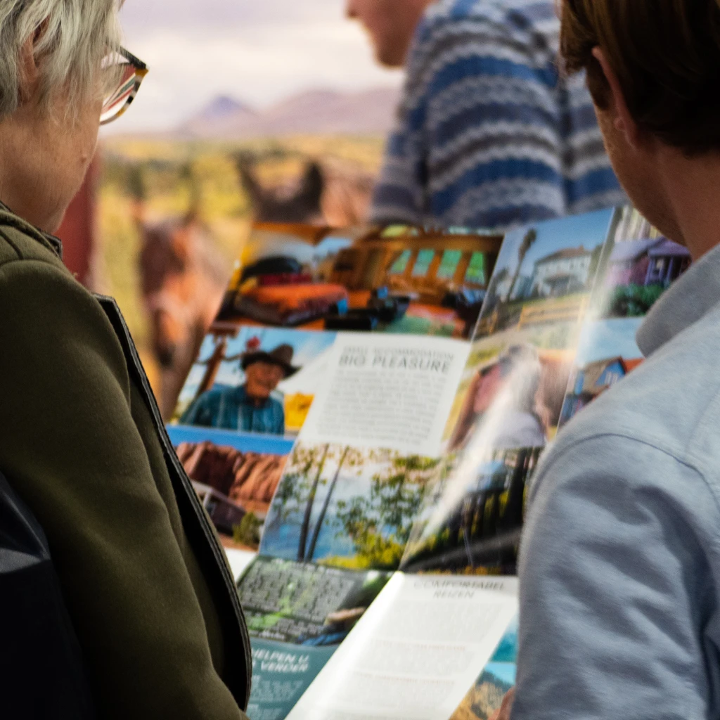 Two people read a Little America brochure to plan their trip to North America