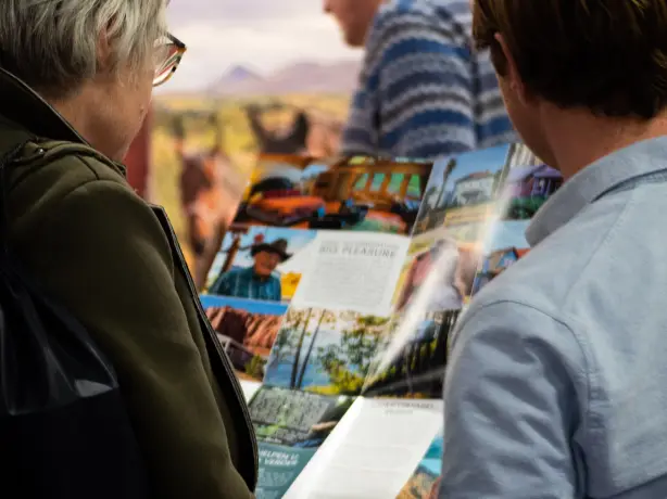 Two people read a Little America brochure to plan their trip to North America