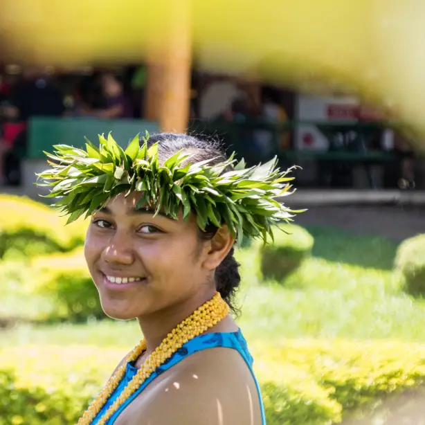 Een vrouw glimlacht naar de camera in een traditionele outfit