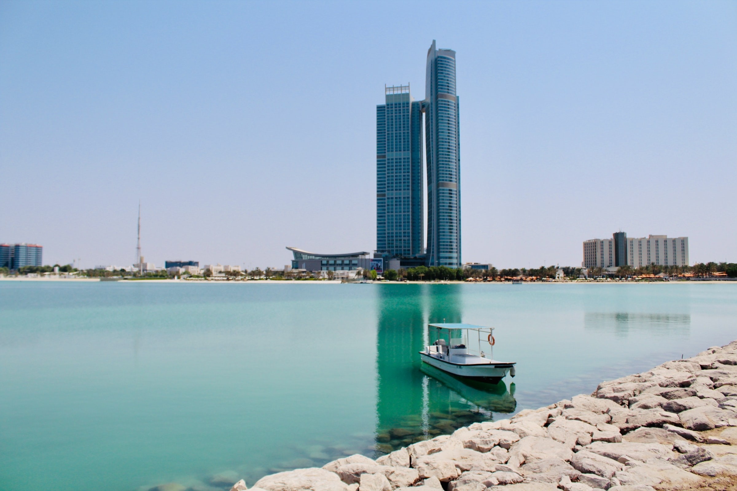 Bucht mit Boot mit Hochhaus im Hintergrund in Abu Dhabi