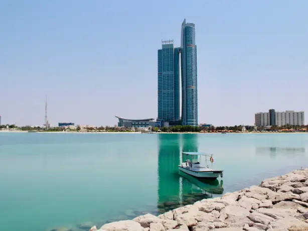 Bucht mit Boot mit Hochhaus im Hintergrund in Abu Dhabi