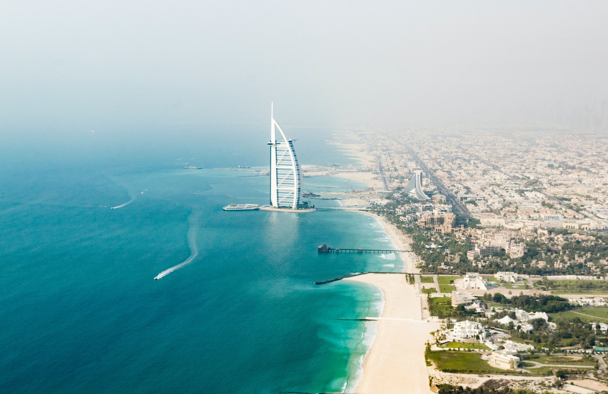 Turm Bujj Al Arab im Wasser mit Küste von Dubai