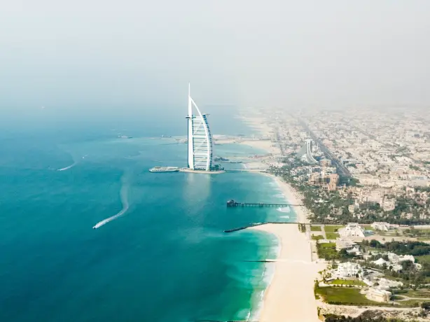 Turm Bujj Al Arab im Wasser mit Küste von Dubai