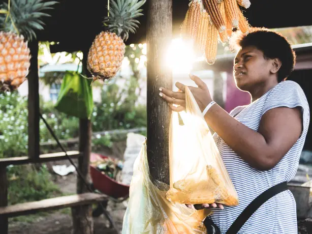 A woman with pineapple and corn