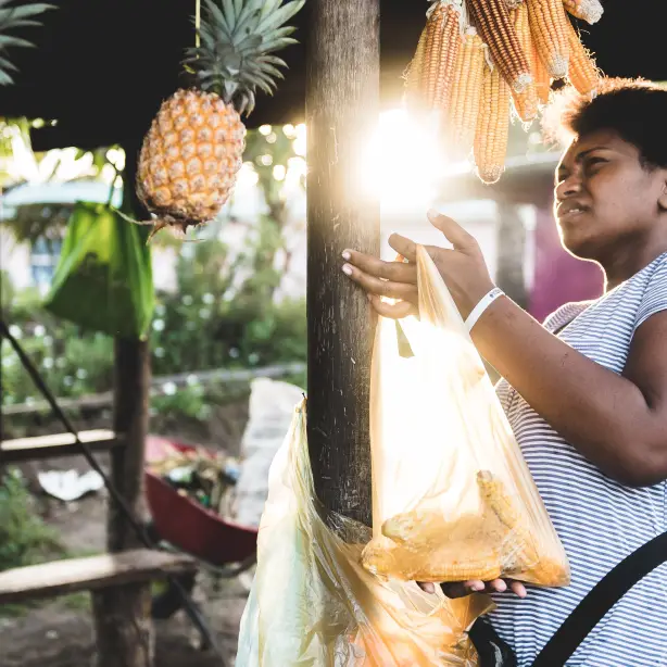 Een vrouw met ananas en maïs