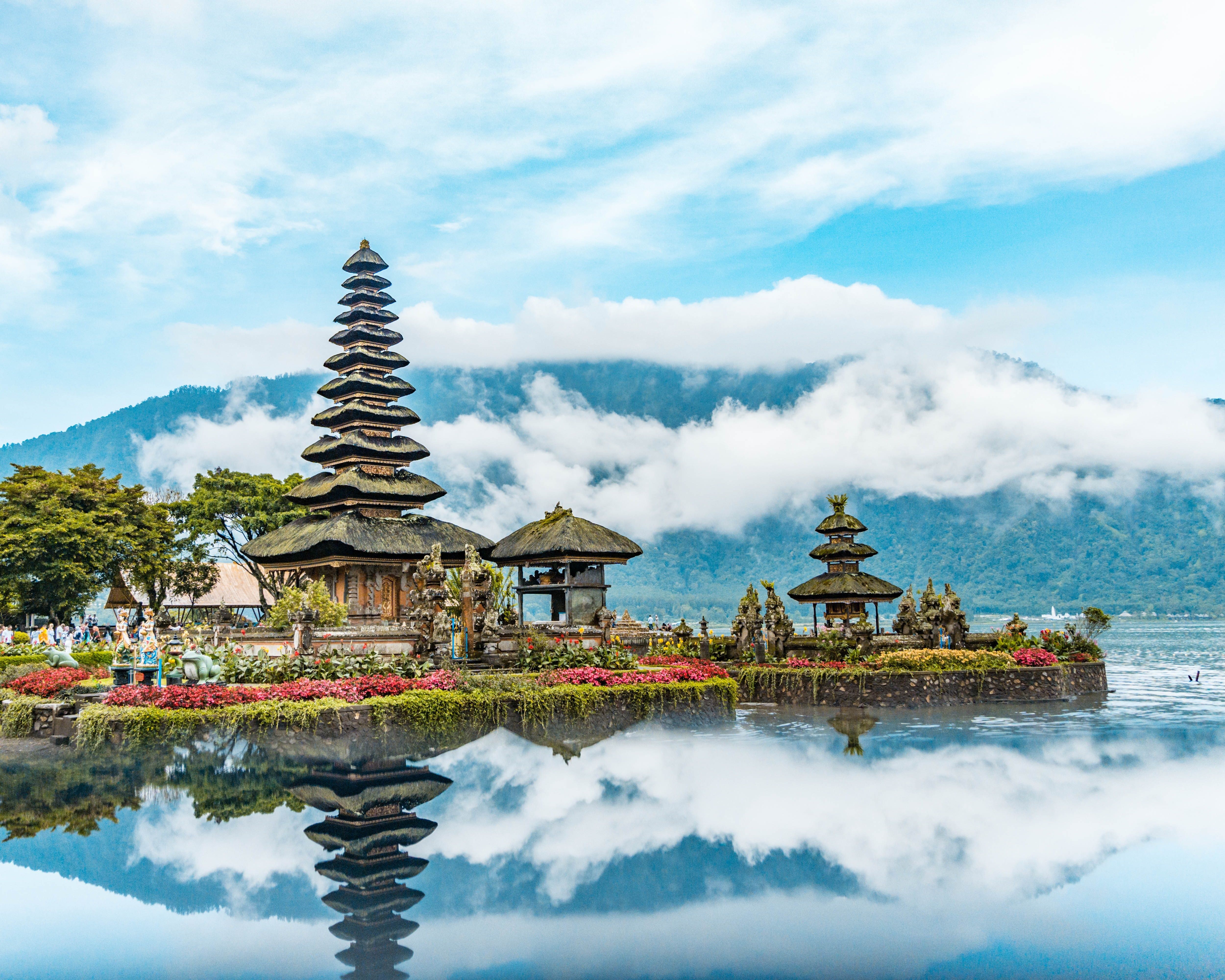 Tempel auf Bali, die sich in Wasser spiegeln mit Bergen im Hintergrund