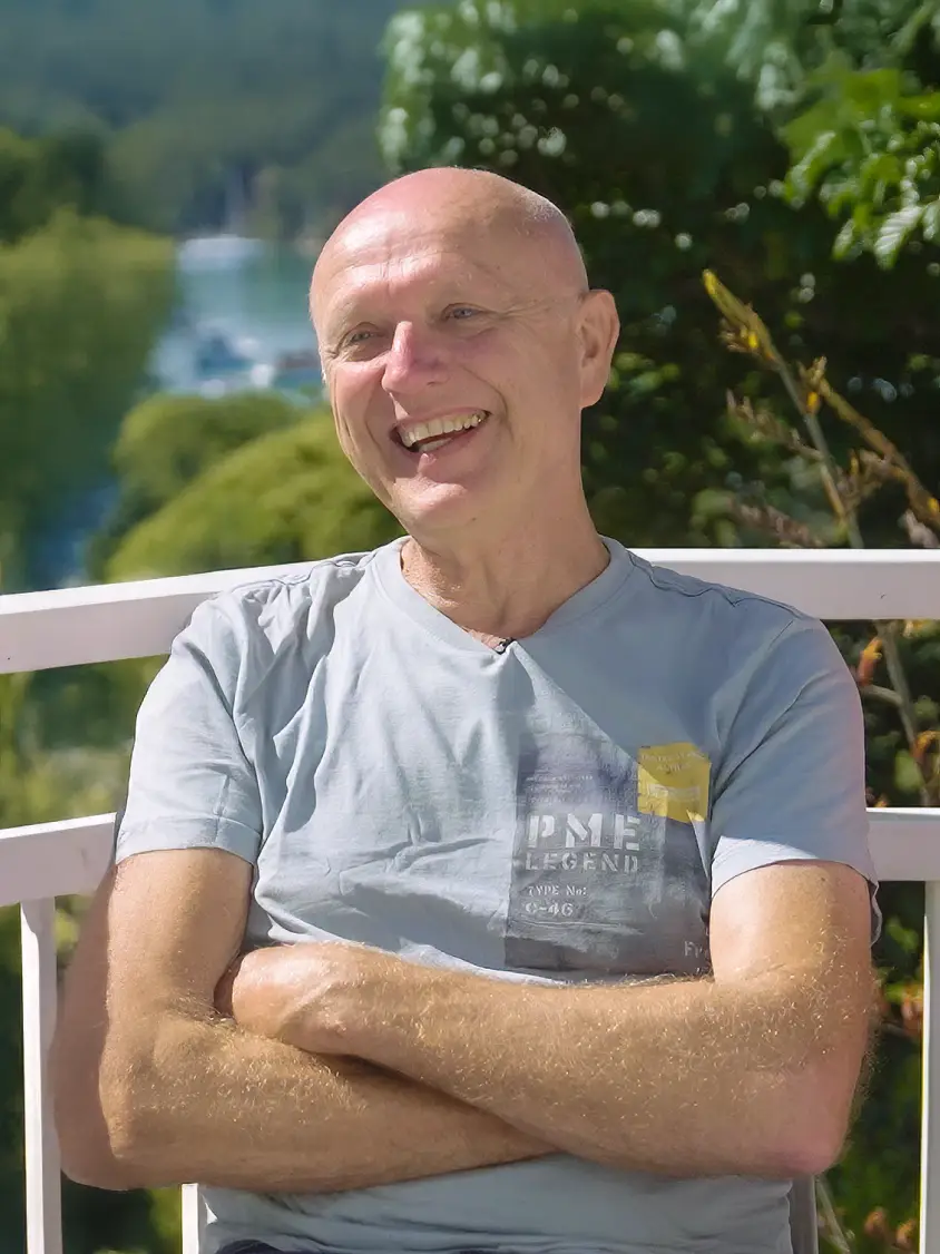 Een man lacht naar de camera