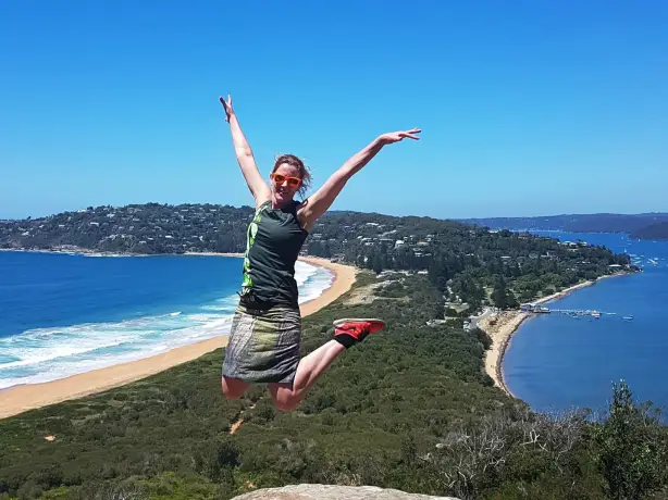 Melanie Springen Pose für die Kamera vor der Palme Strand, Australien