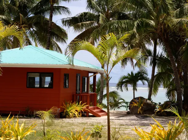 Bella Beach bungalows with ocean in the background in the Cook Islands