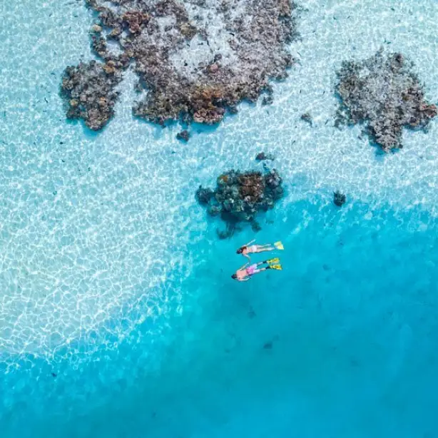 Luchtfoto van een stel dat snorkelt in de baaien van Cookeilanden