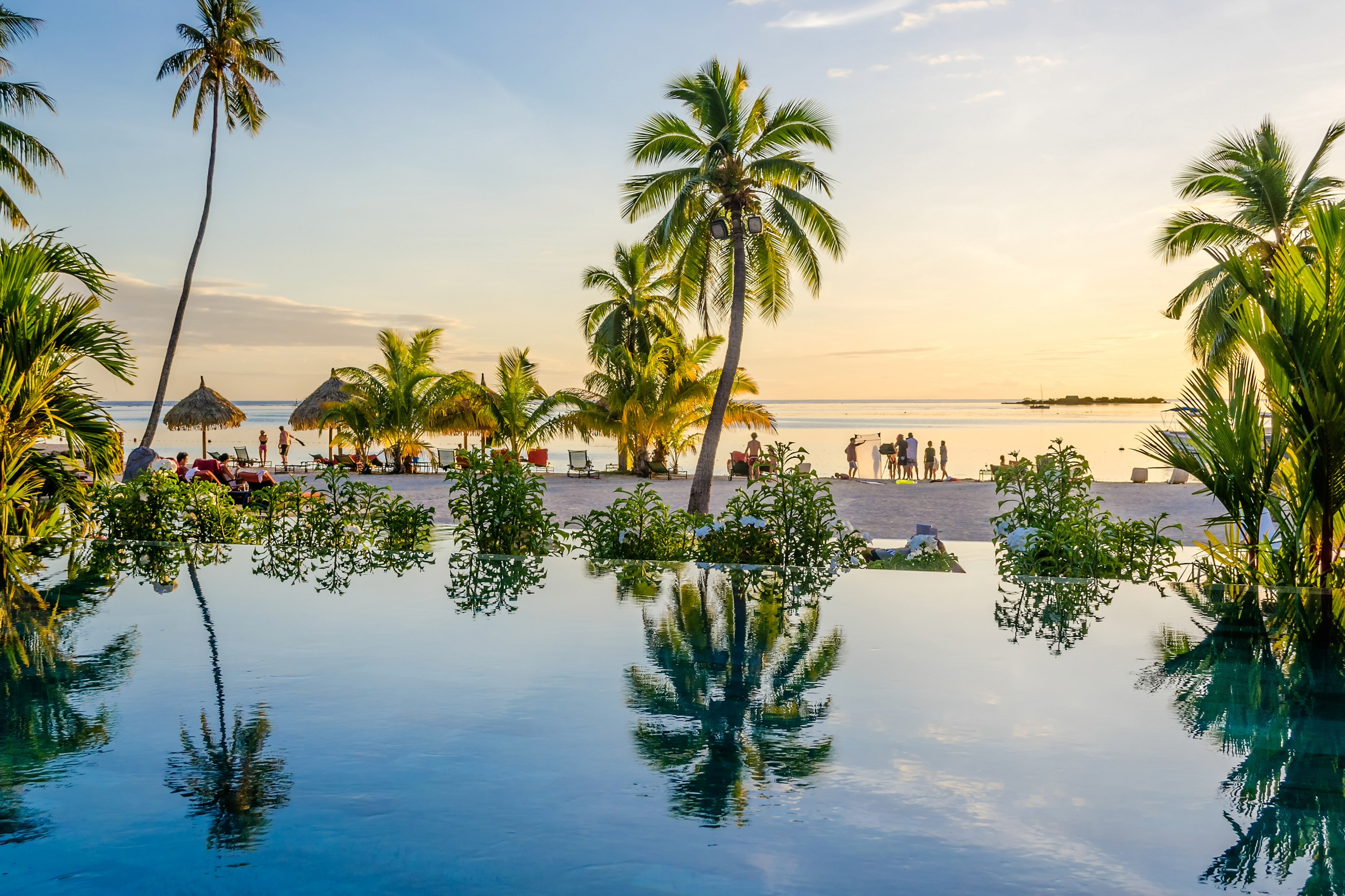 Palmbomen en het strand met zonsondergang op de achtergrond in Tahiti