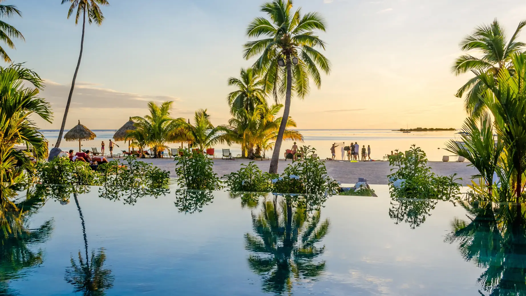 Palmbomen en het strand met zonsondergang op de achtergrond in Tahiti