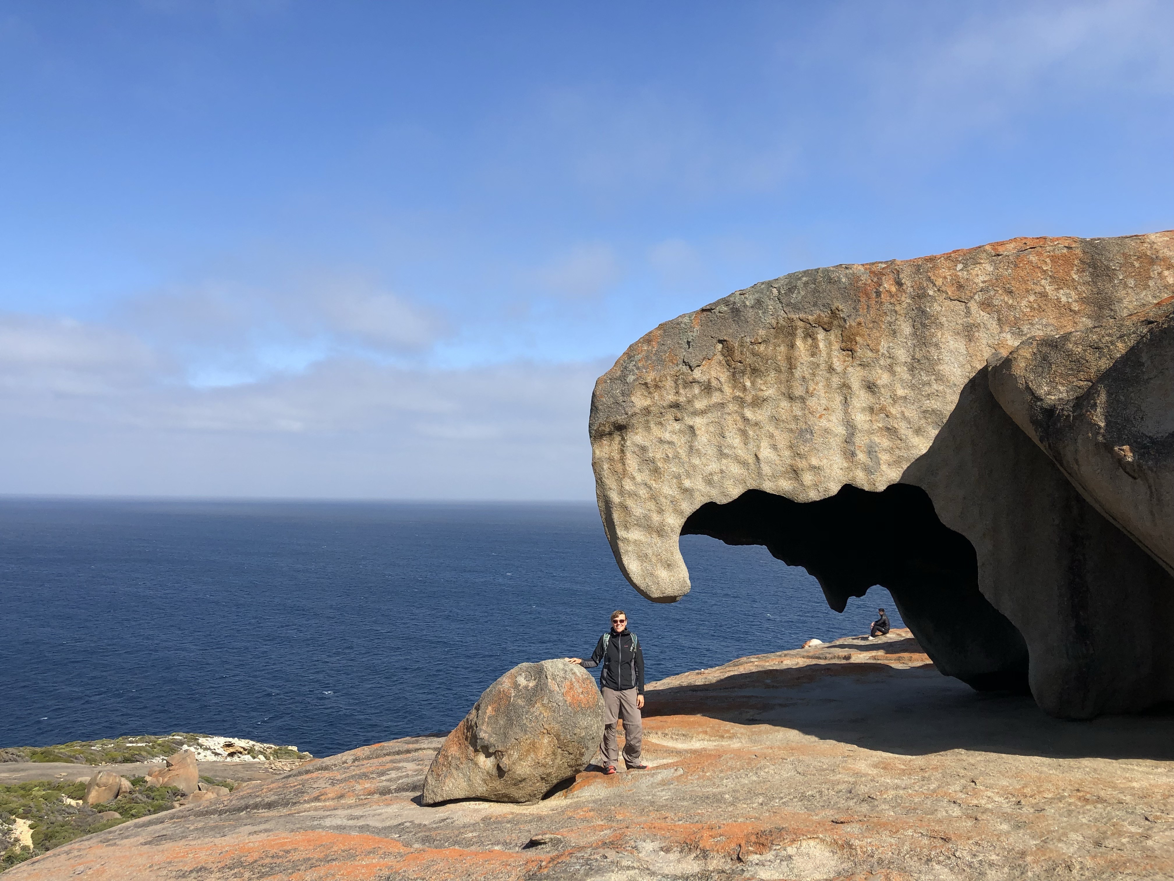 Frau steht unter großem Felsen in Australien