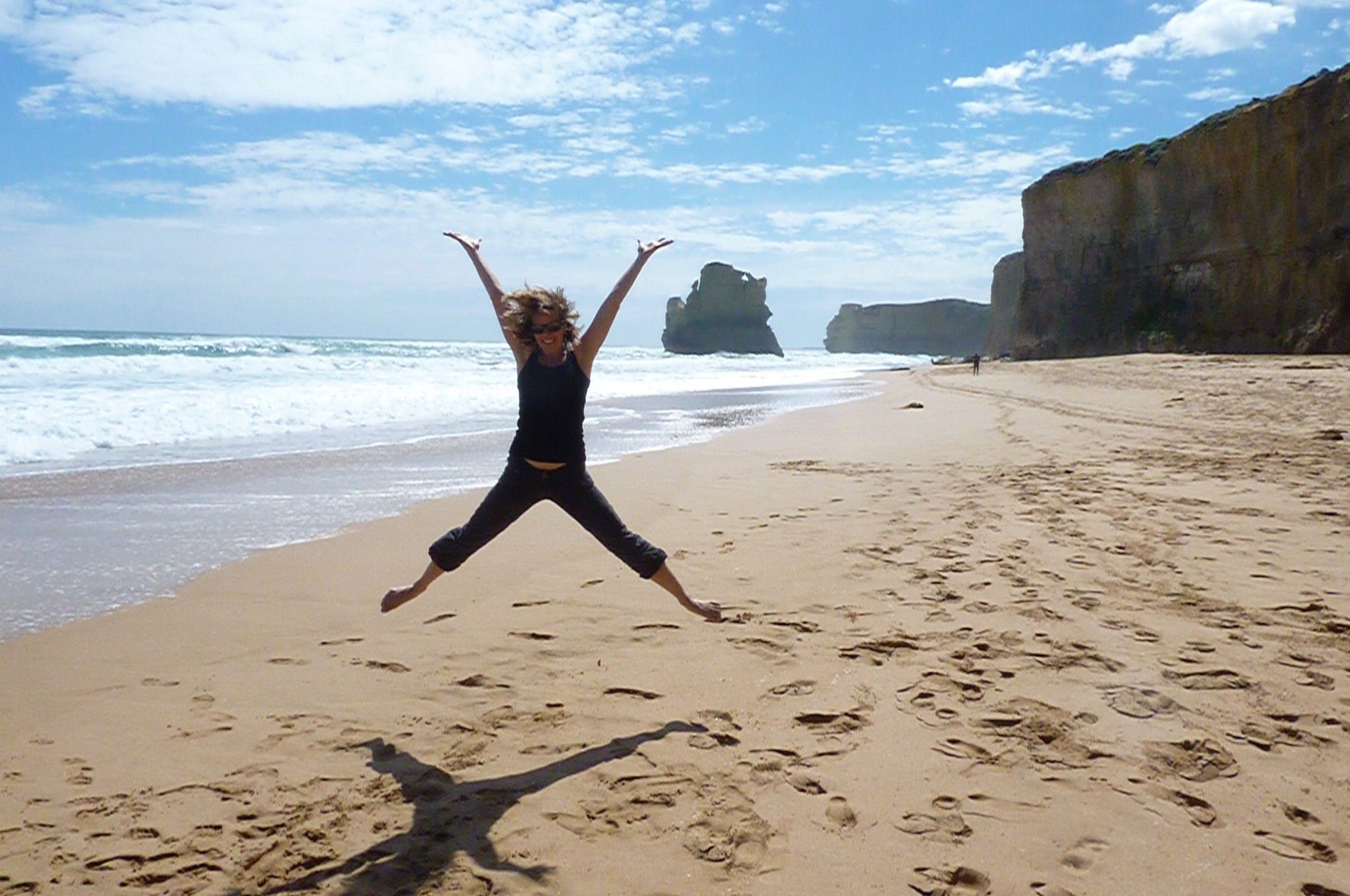 Frau springt an Strand von Australien
