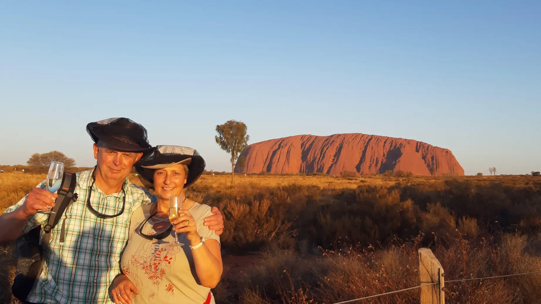 A couple sip champagne in front of Uluru / Ayers Rock
