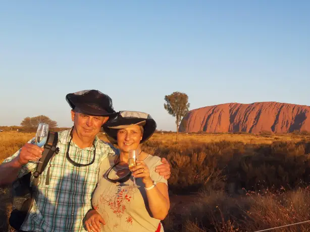 A couple sip champagne in front of Uluru / Ayers Rock