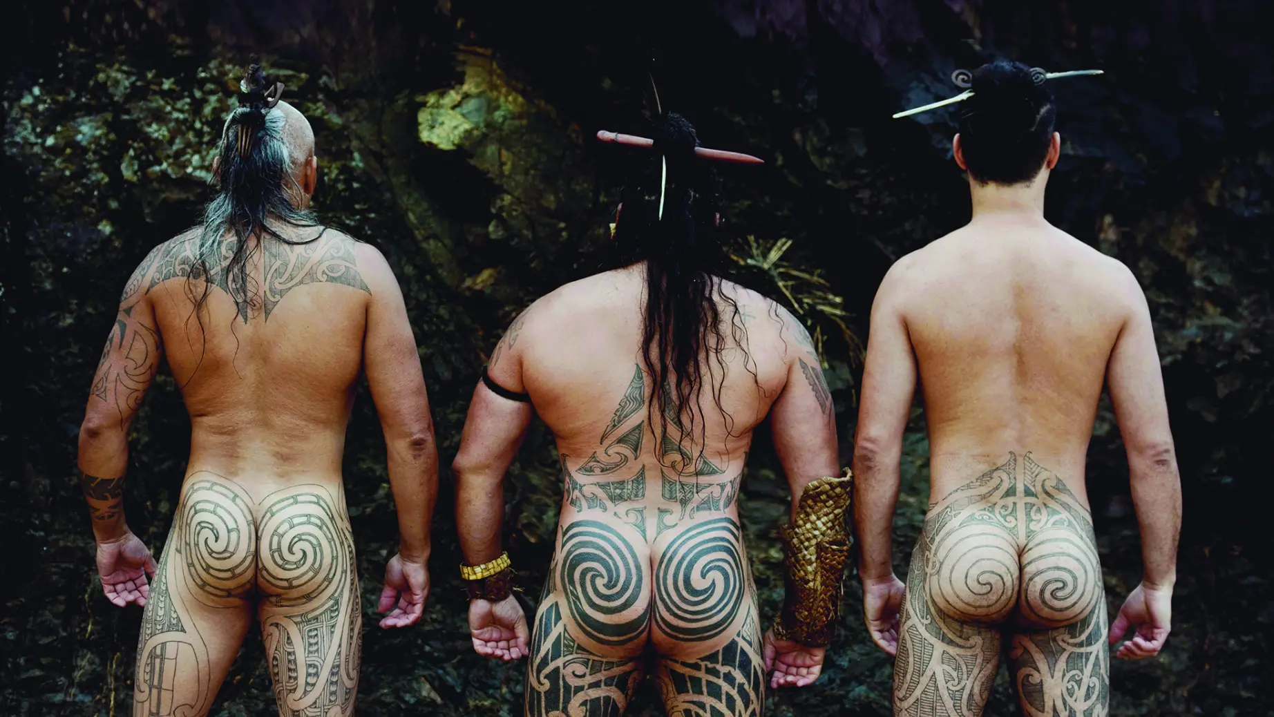 Drei Maori-Männer mit Hintern- und Rückentattoos