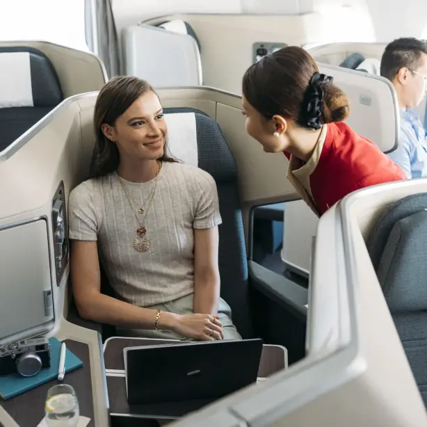 Cathay Pacific Flugbegleiter im Gespräch mit einem Passagier