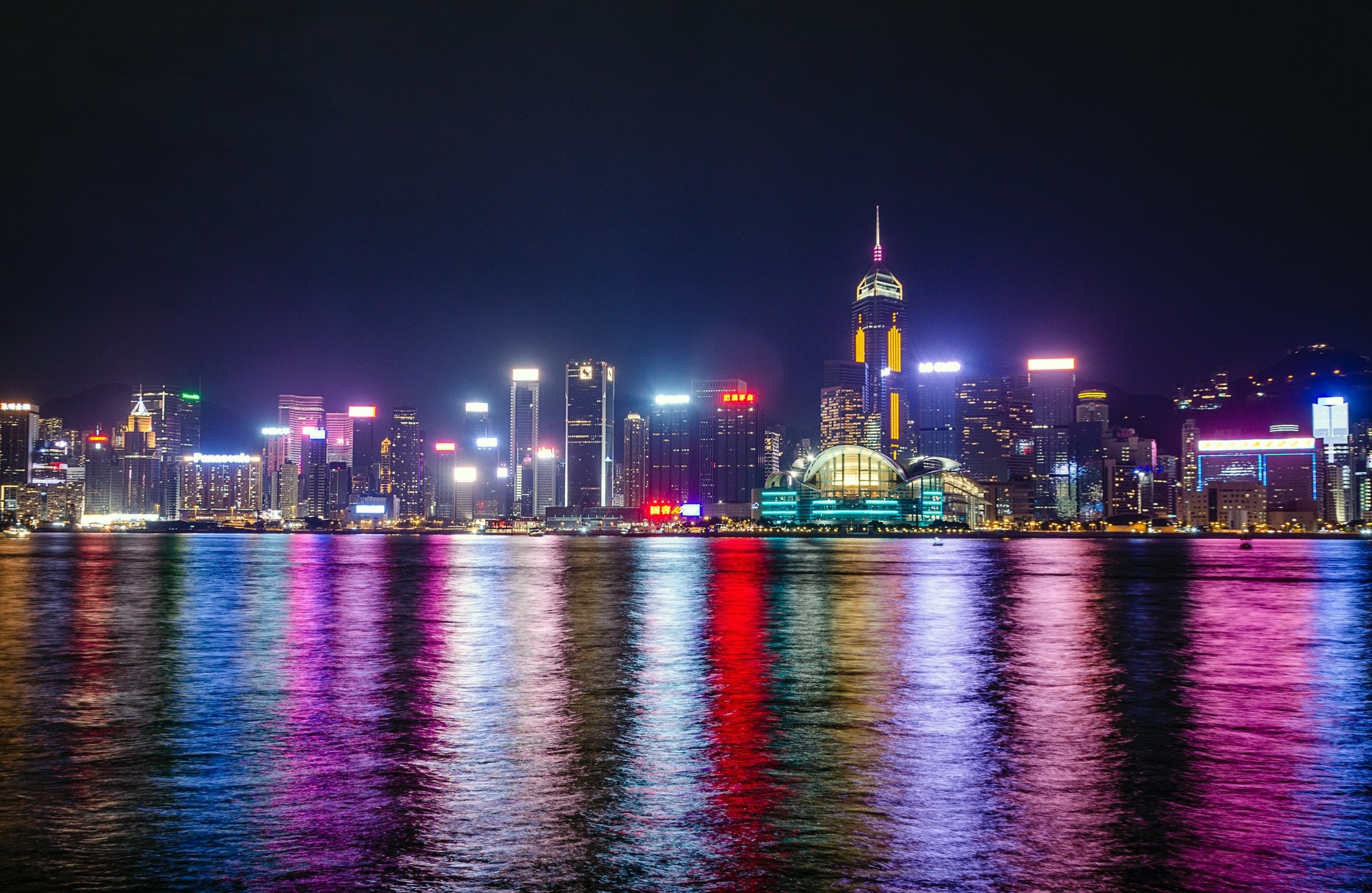 Skyline of Hong-Kong city at night with colourful lights reflecting off water
