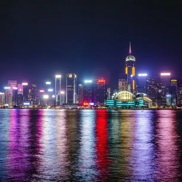 Skyline of Hong-Kong city at night with colourful lights reflecting off water