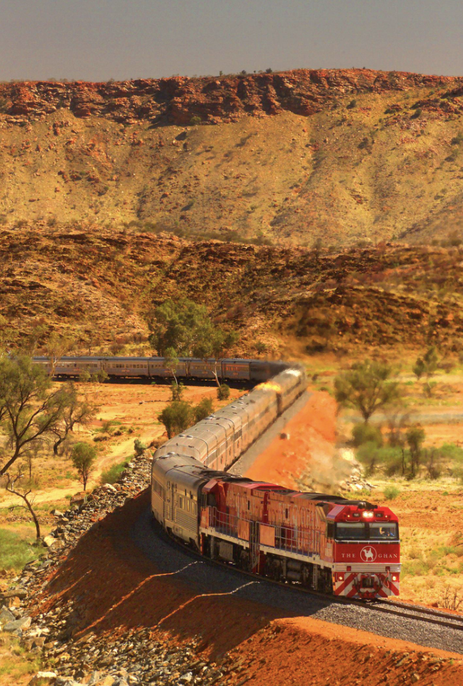 The famous Australian Ghan train travels through a red rock landscape