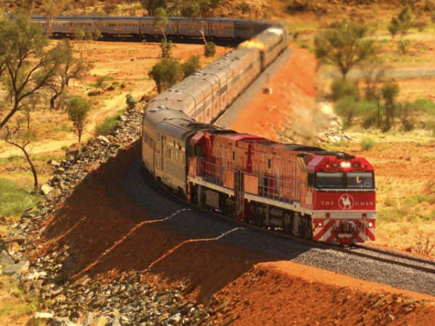 The famous Australian Ghan train travels through a red rock landscape